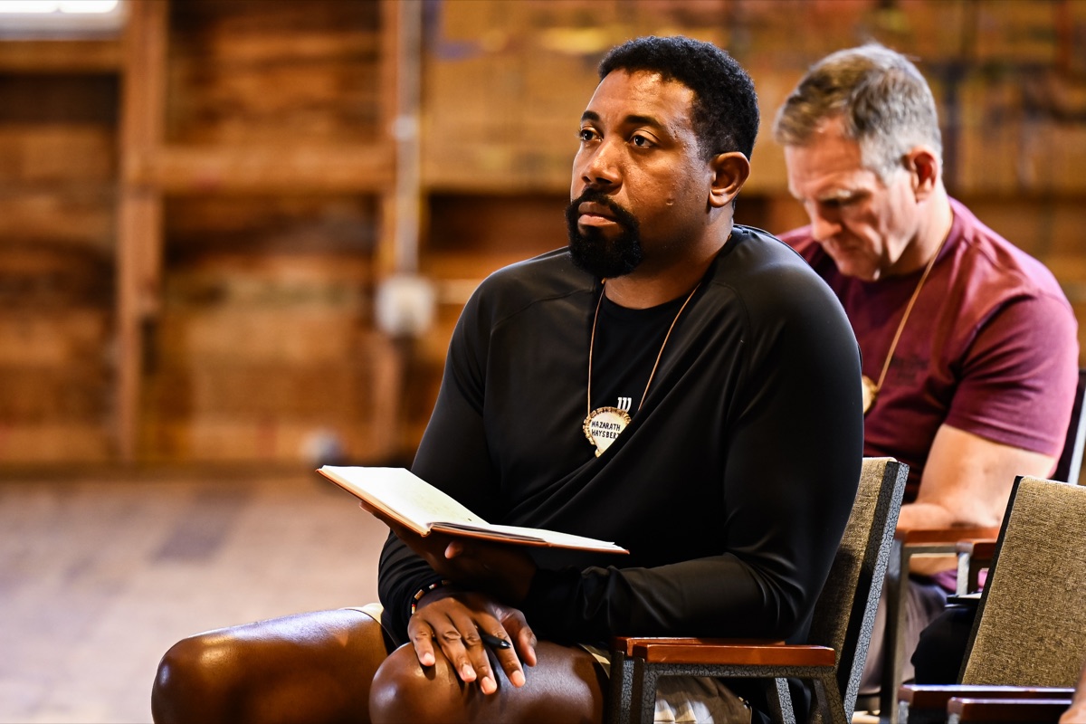 A graduate reading from his notes in the barn